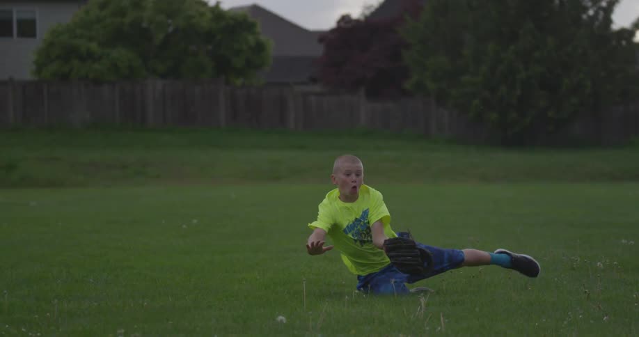 A boy jumps forward to catch a ball