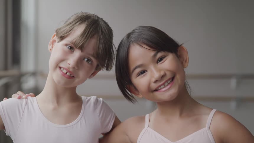 Two young ballerinas smiles for the camera