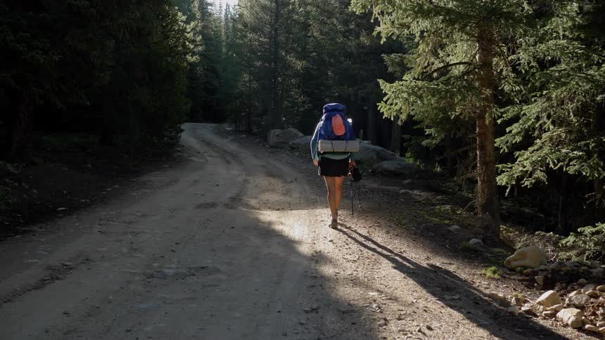 A woman hikes along a dirt path