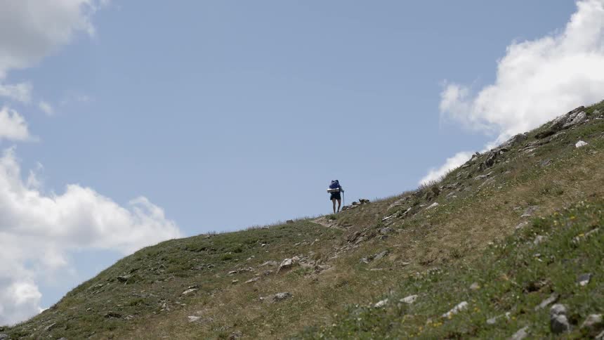 A hiker walks up a hill
