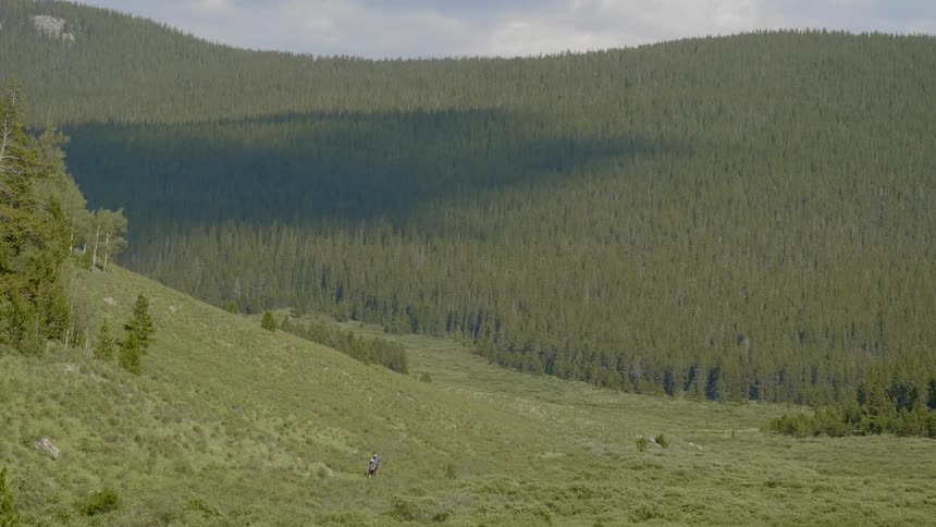 Two people in the distance are hiking uphill
