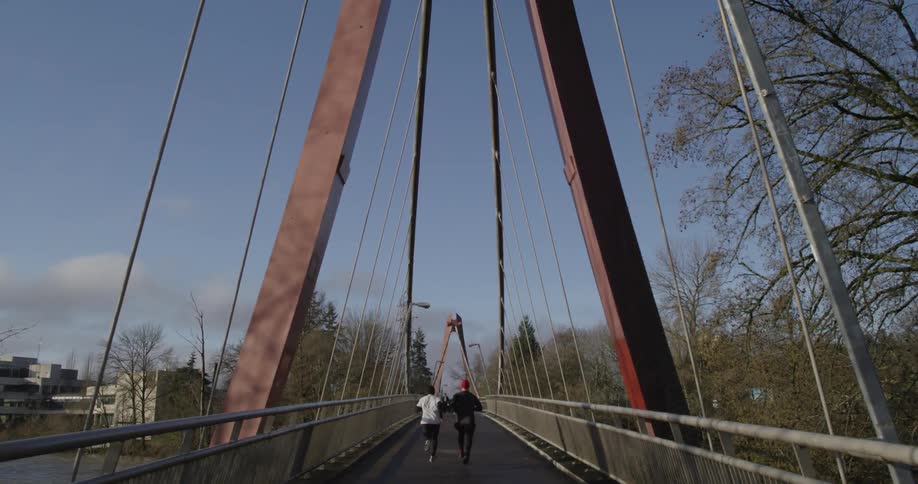 People jog across a bridge in the winter