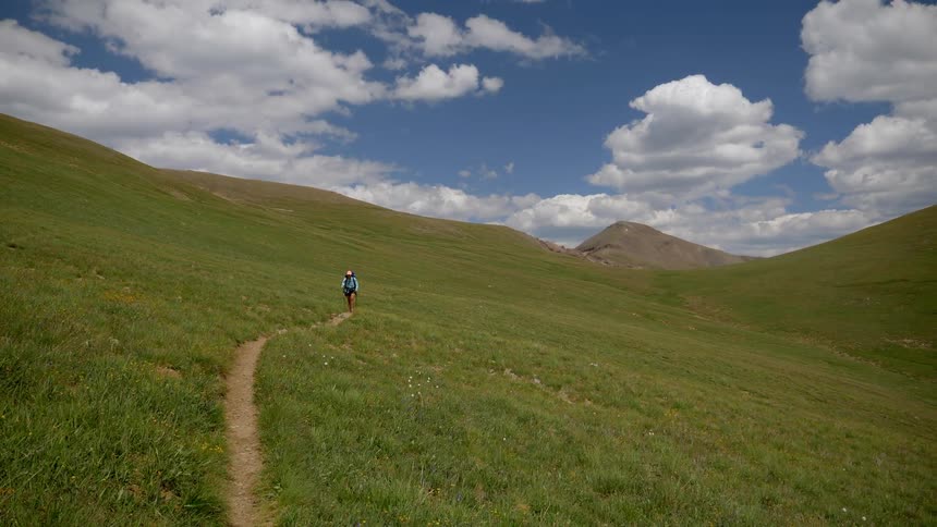 Person walking along a dirt trail in the countryside