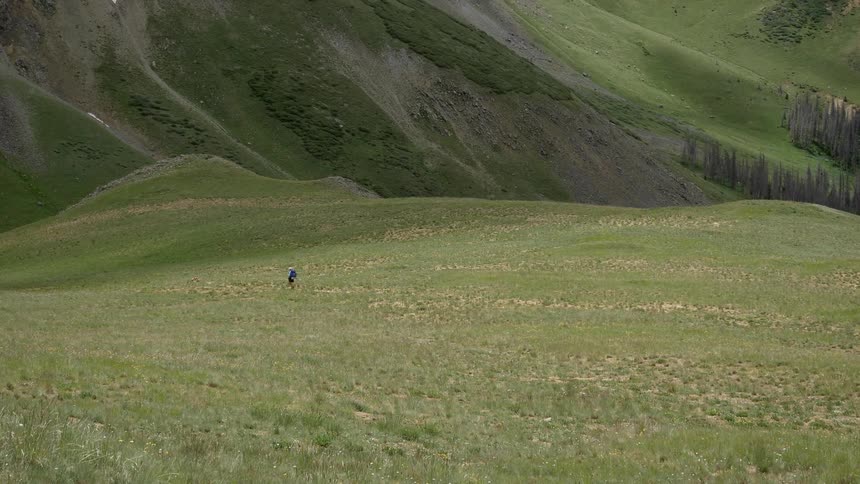 A lone person walking on a trail in the distance in the countryside