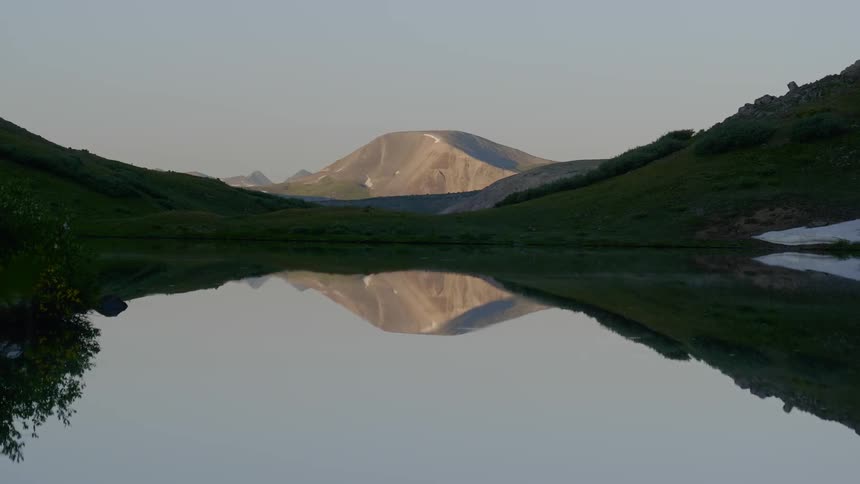 A calm lake surrounded by green hills