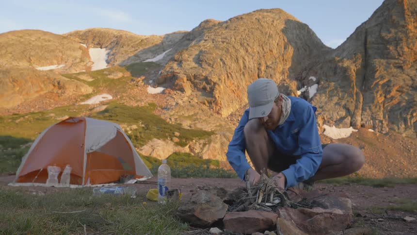 Man tries to light the campfire in the camp
