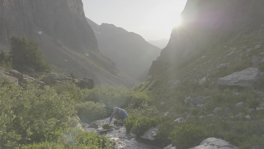 A scenery of a sun going through between mountain