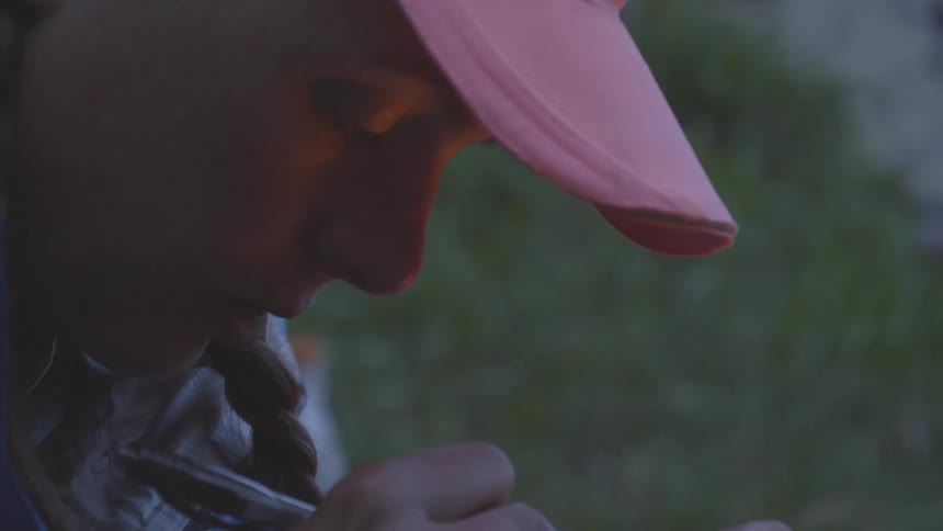 Female write on a paper in front of a bon fire