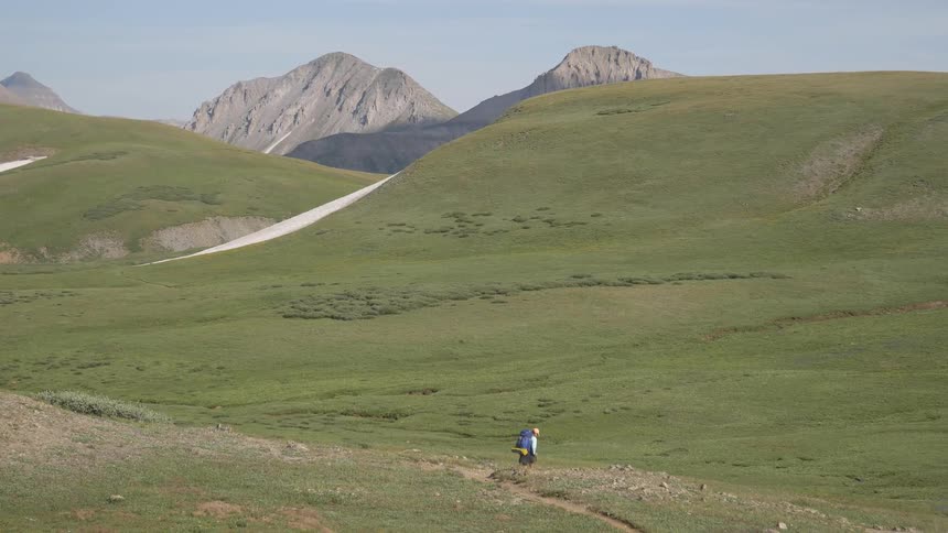 A man hiking alone at the grass land