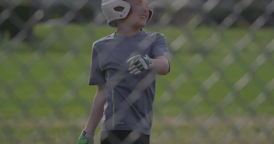 A boy swings a bat at a baseball