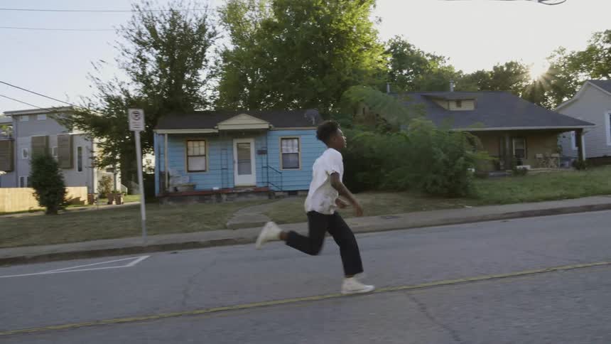 A black boy running in the neigborhood