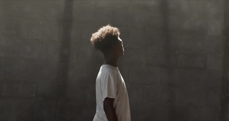 A young man looking up at a stone wall