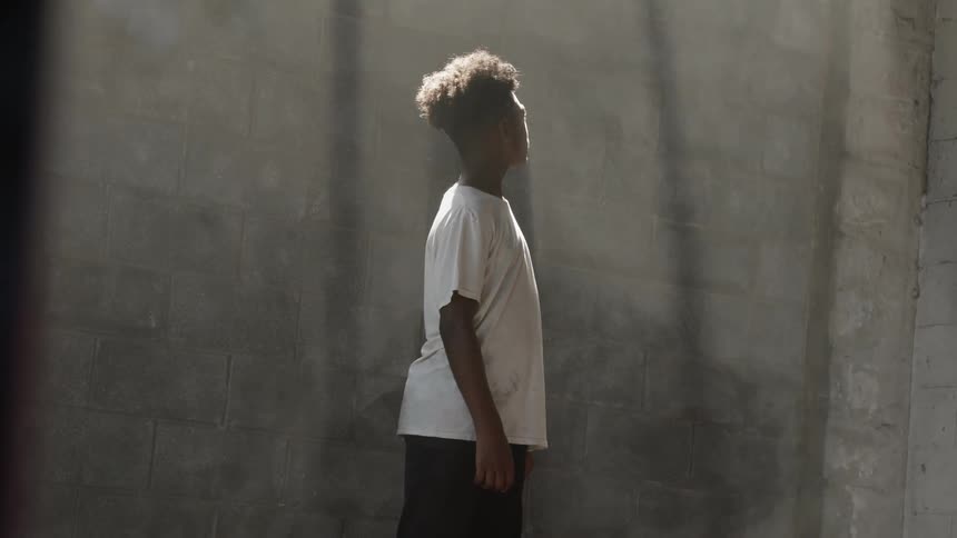 A black man standing in front of a wall
