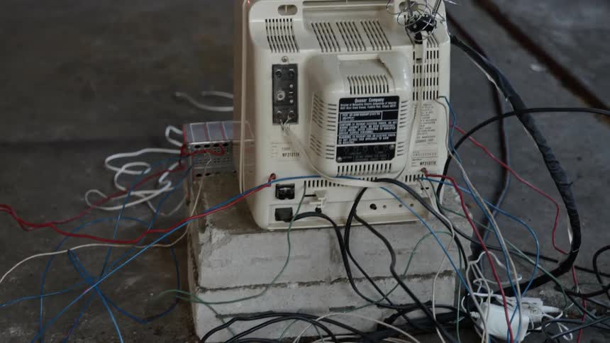 Electronics with antenna and many colored wires sits on the floor