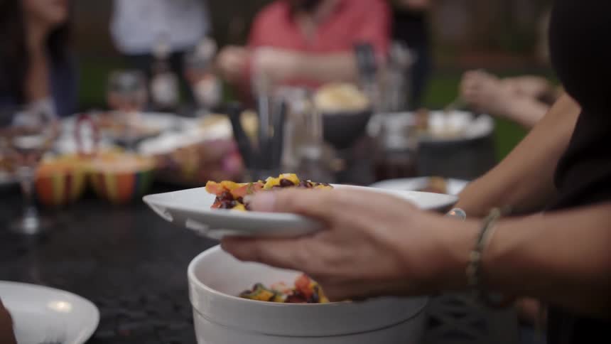 People are sitting at a table eating plates of food