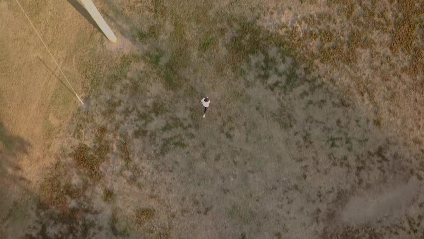 Aerial shot of a man running in a field