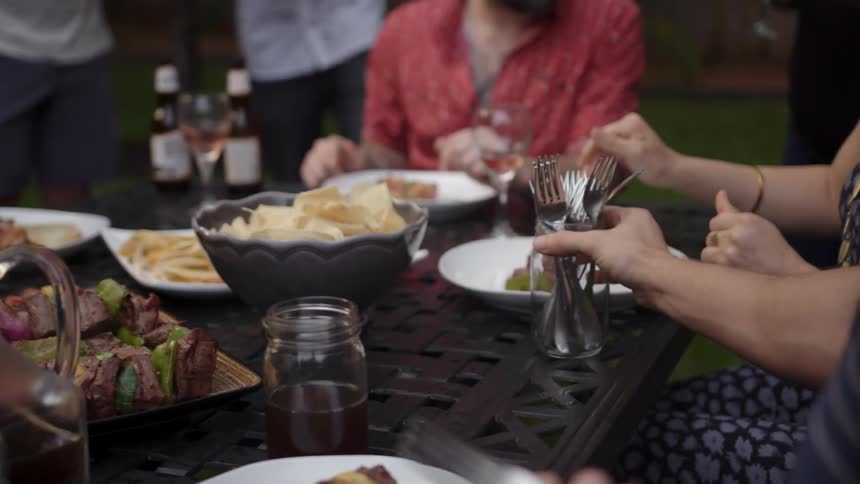 A person passing silverware at a table