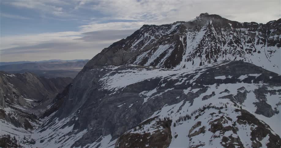 A snow covered mountain on a mostly cloudy day