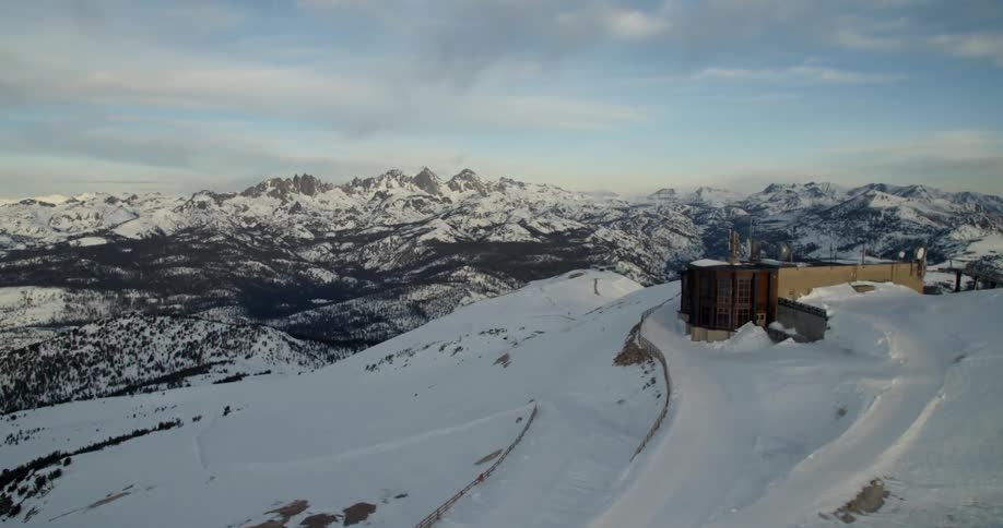 A building sits on a snowy hill in the mountains