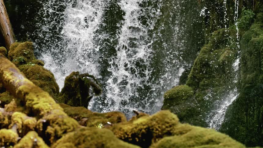 Water falling onto moss covered rocks