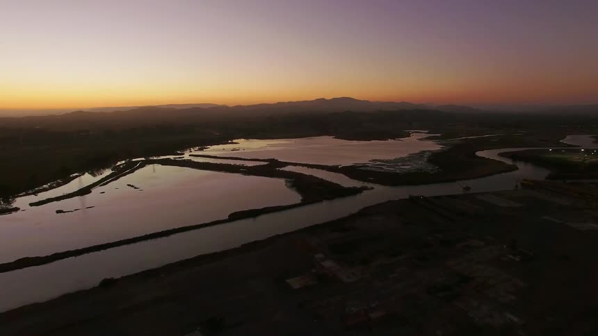 As the sun has set just below the horizon a large river flows calmly