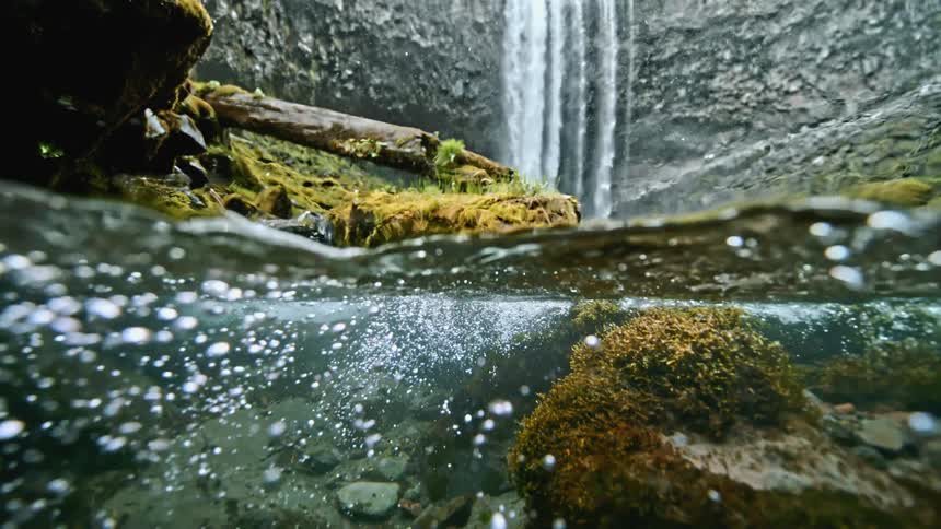 Half underwater view of a river and waterfall
