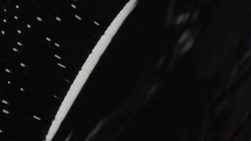 Small bubbles catch the light as the move to the surface of a dark liquid