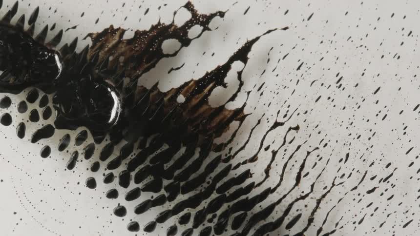 A black oil and water mix sliding across a bowl