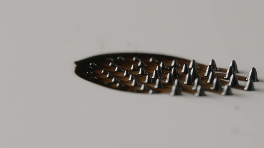 Small cones form from black liquid and move around