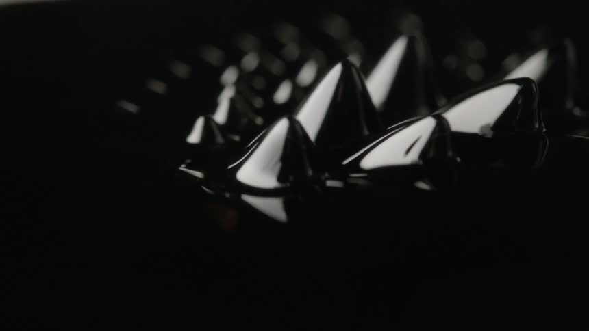 Spike shaped bumps rising from a shiny black substance