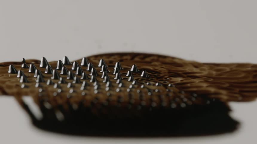 A ferrofluid moves on a white surface