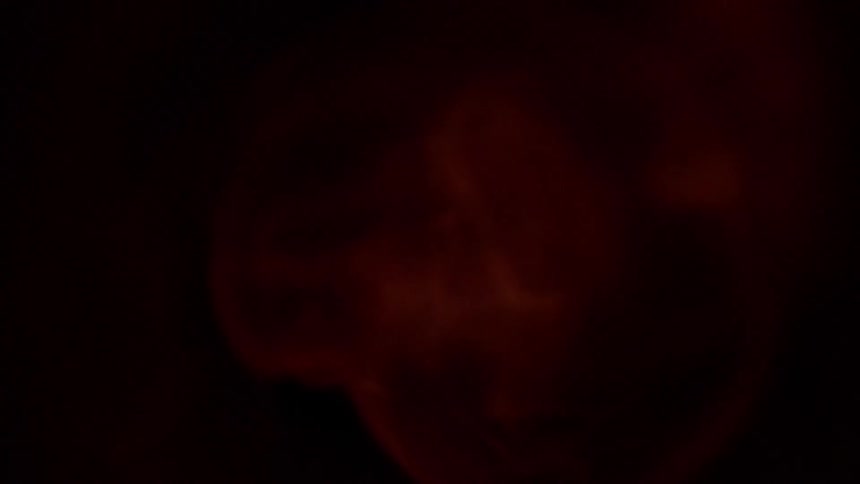 A flame burns and swirls within a metal cylinder before snuffing out which leads to darkness