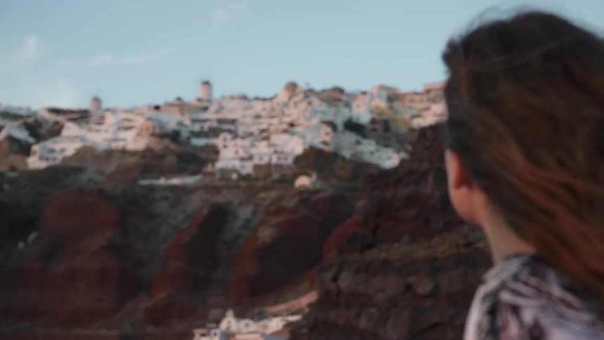 Woman looks out over the city under a blue sky