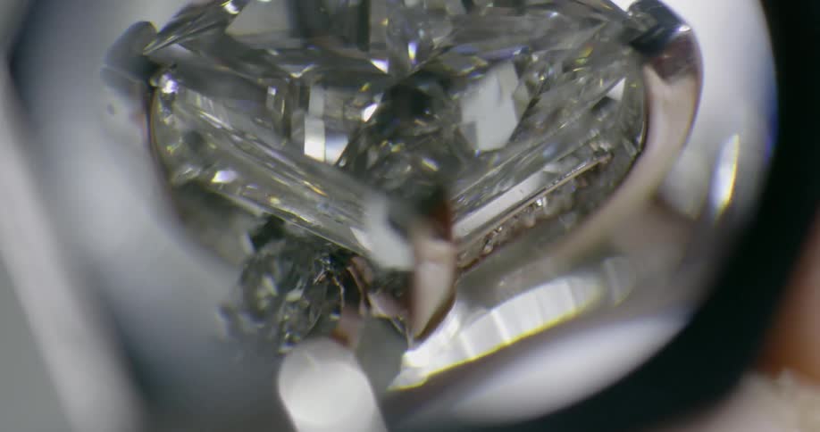 A diamond under a magnifying glass in a ring setting