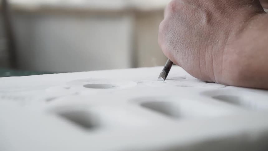 A man chisels some stone