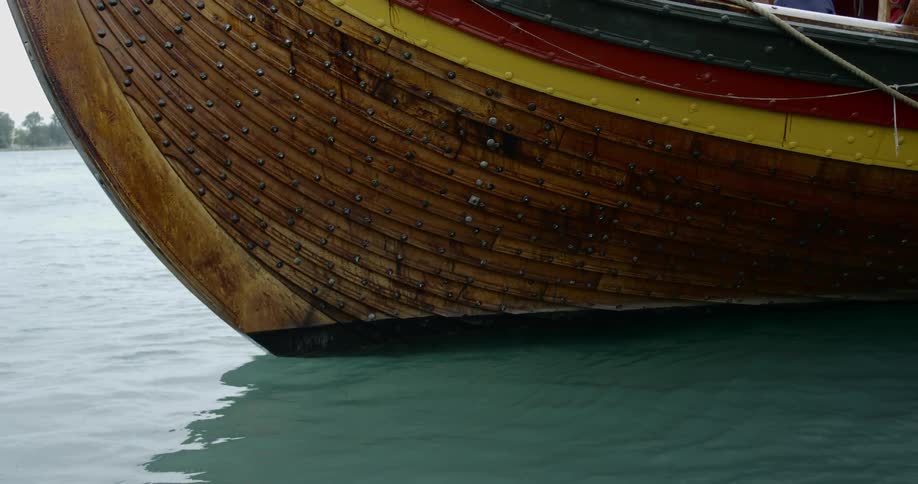 A wooden sea vessel flying in a turquoise body of water