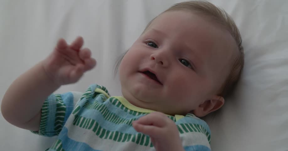 A very happy baby looks up at a person