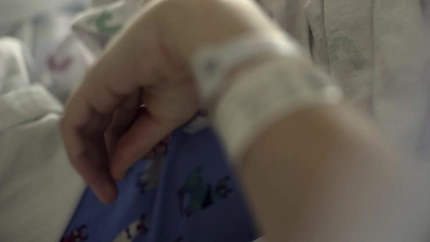 A new mother rubs her newborn's feet while still admitted to the hospital