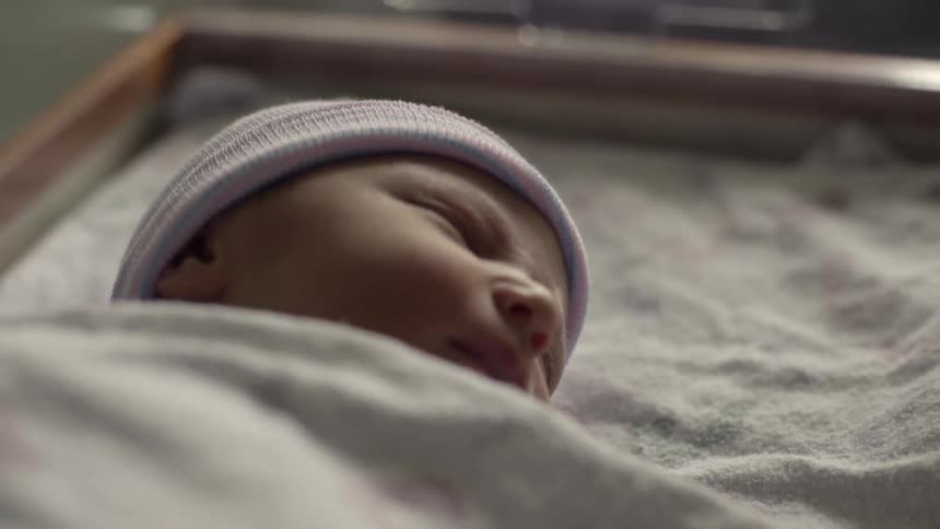 A sleeping infant opens his eyes for a moment