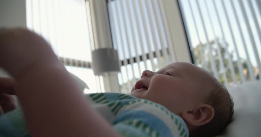 A baby laughing on the floor