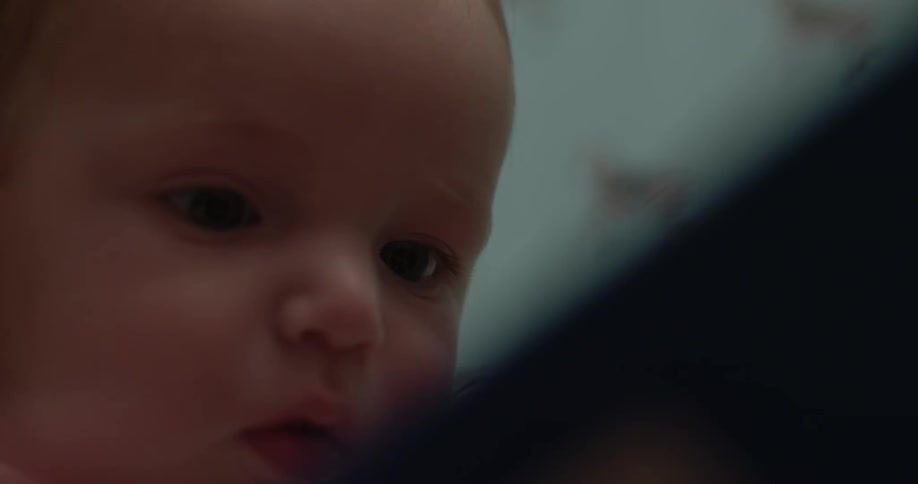 A baby tries to touch an object