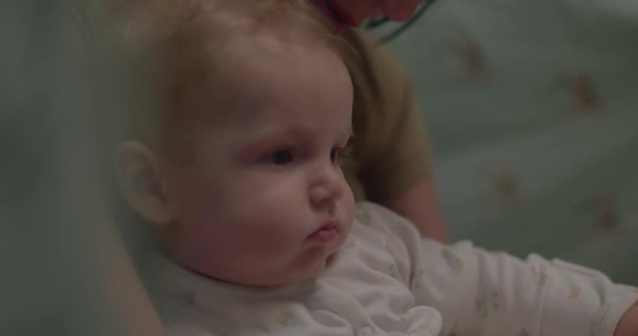 A baby sits on a woman's lap