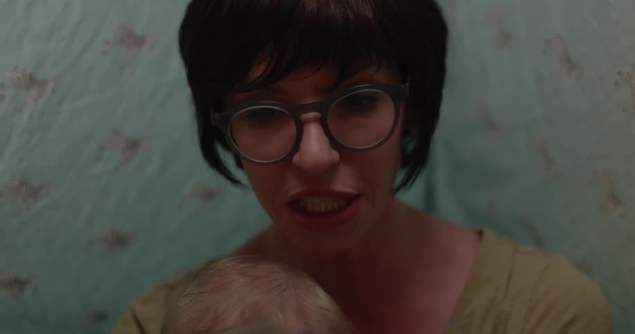 A woman in glasses reads to a baby