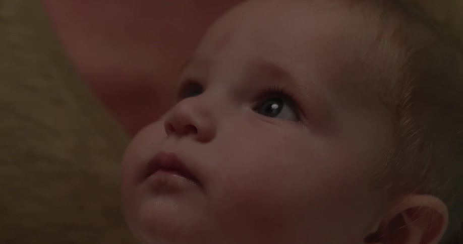 Close up of a baby looking up and following something with his eyes