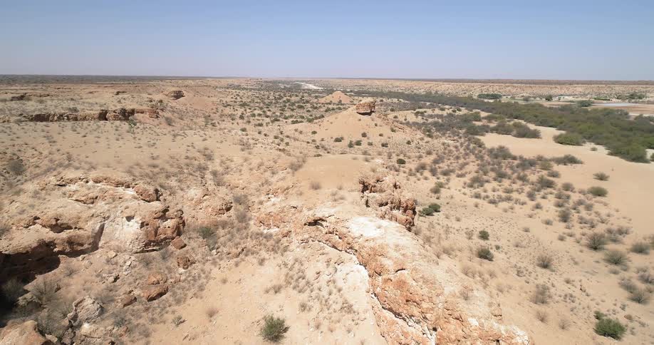 An aerial view of rocks and shrubs covering a desert landscape