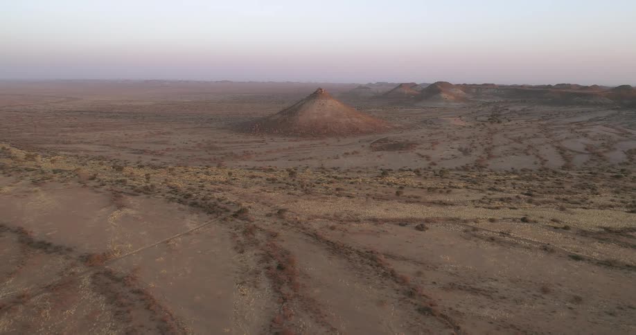 A desert with mounds with the sky in the background