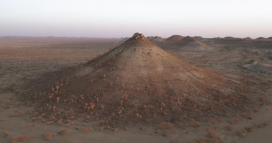 A desert with mounds with the sky in the background