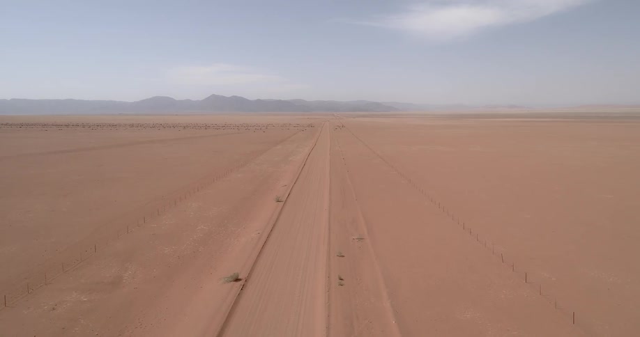 Parallel lines in the sand mark a makeshift road in the desert