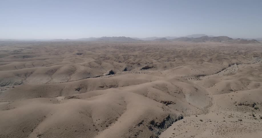 A desert and mountains are in the horizon