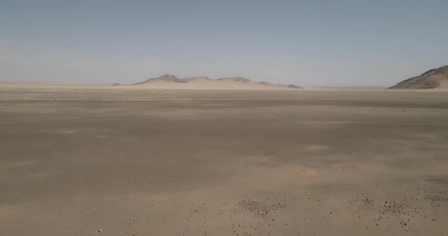 Two dirt hills sit in a barren desert